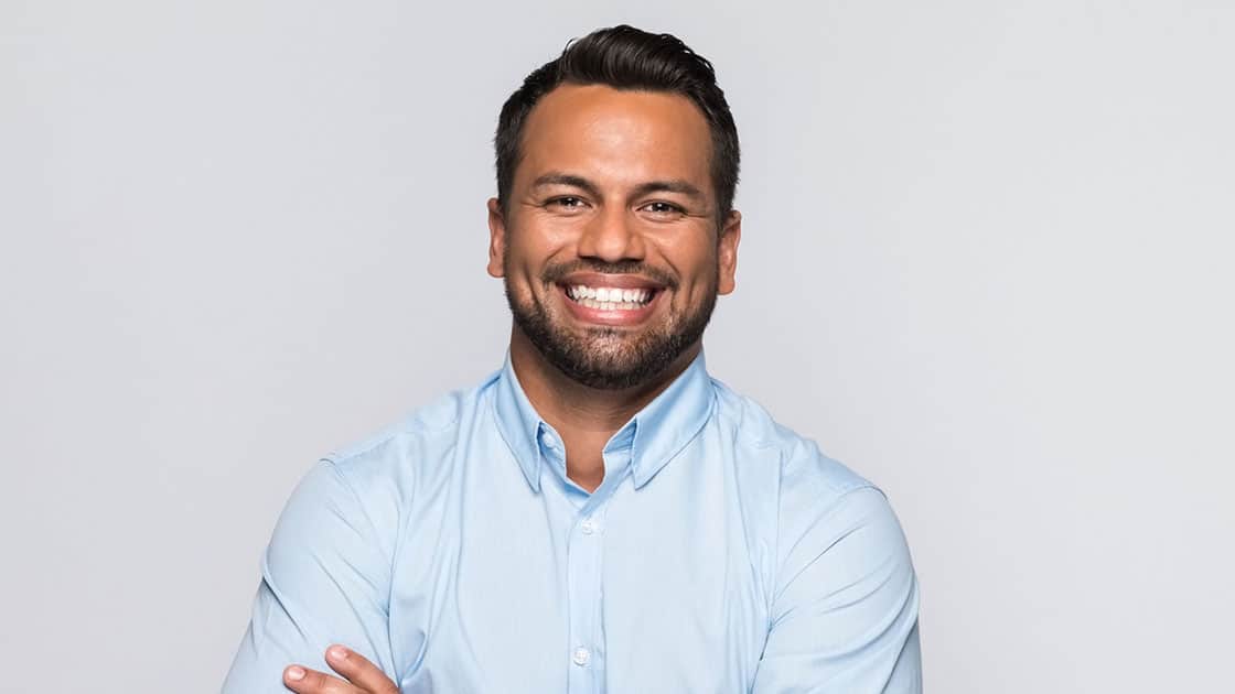 man smiling with arms folded