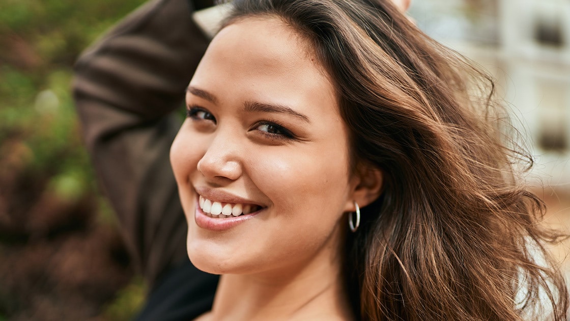 Young hispanic woman smiling happy standing at the city.