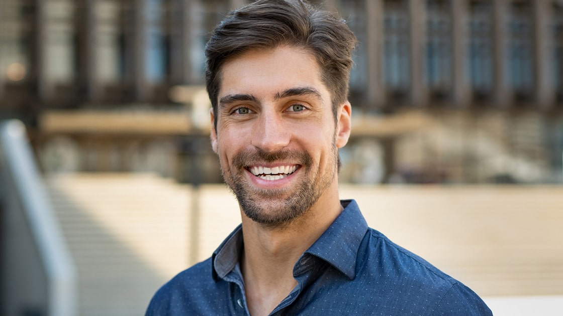 smiling man with blue collard shirt